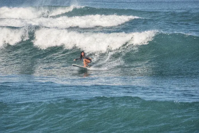 Una surfista en una ola verde en Santa Teresa